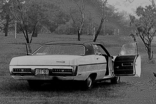 A black and white photo of a car with its two front doors open