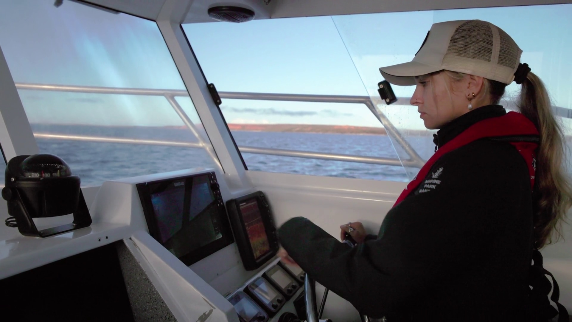 Una joven conduce un barco.
