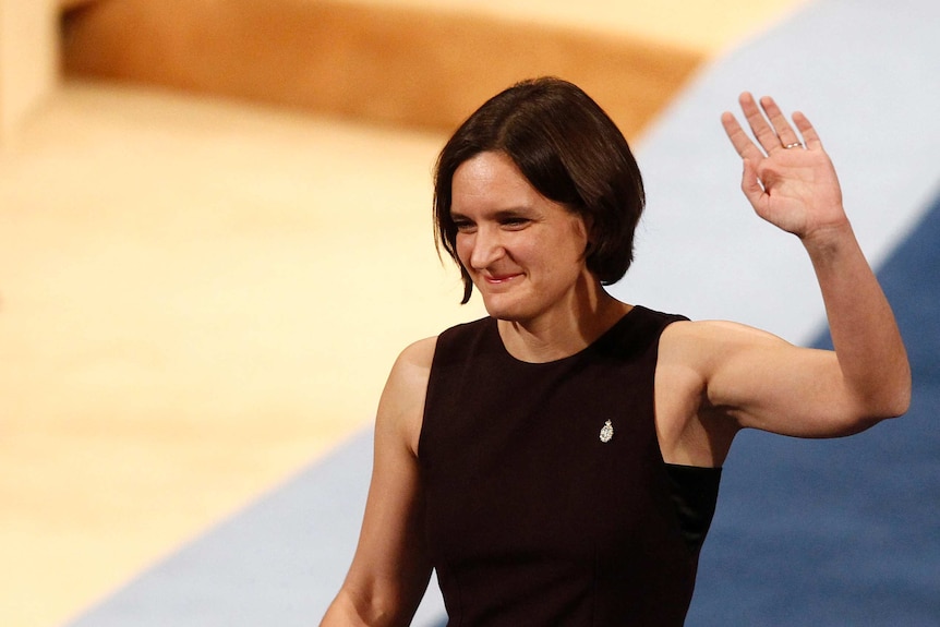 Nobel Prize winner Esther Duflo wears black and waves at a crowd