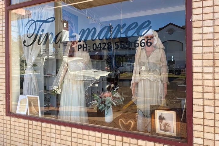 A shop window sees two mannequins dressed in wedding gowns displayed