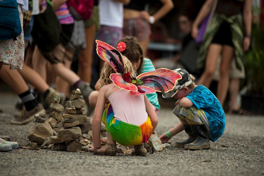 A child dressed as a fairy plays on the streets at Woodford Folk Festival