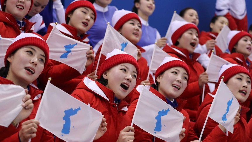 North Korean cheerleaders sing and cheer on the sidelines