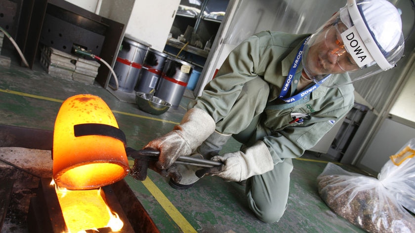 A worker pours molten gold, recycled from components of mobile phones.