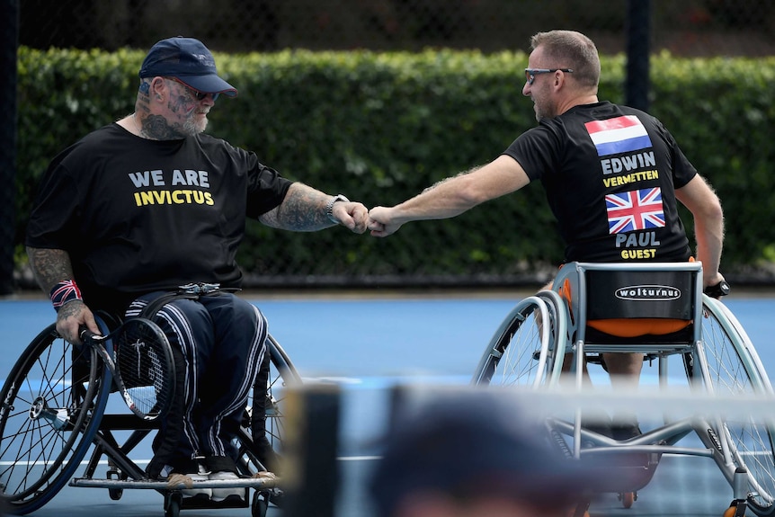 Wheelchair doubles partners Paul Guest and Edwin Vermetten share a fist bump on court.