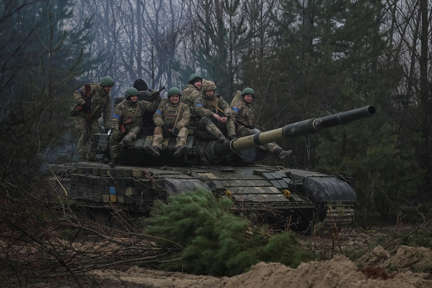 Ukrainian servicemen on top of a military tank.