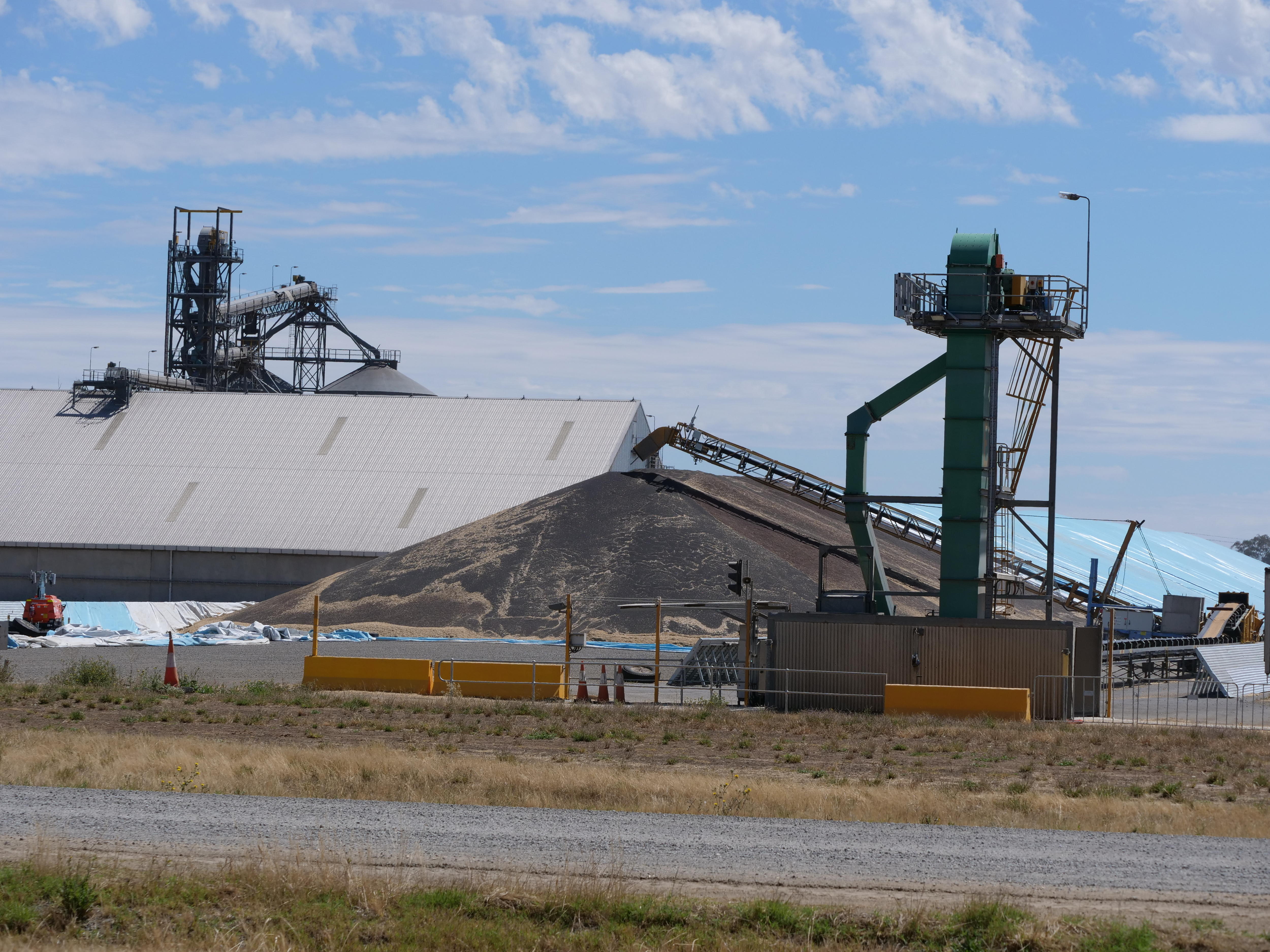 Large grain sheds, mounds of grain and mechanical towers in western Victoria.