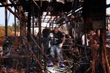 Israeli forensics search in the remains of a burnt-out a bus.