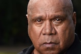 Indigenous musician Archie Roach stares into the camera lens as his portrait is taken.
