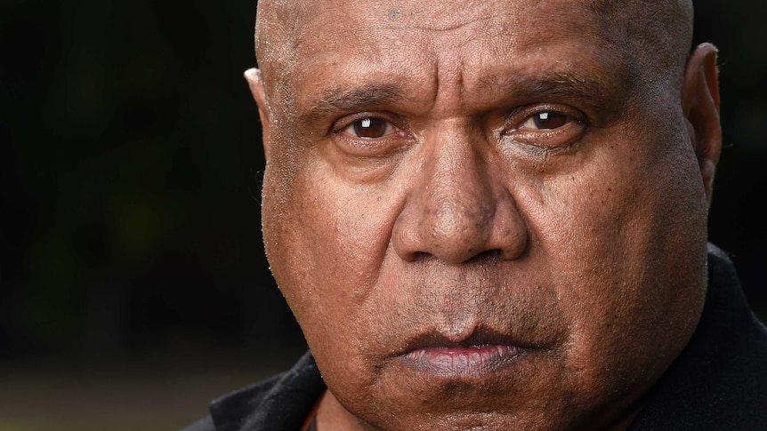 Indigenous musician Archie Roach stares into the camera lens as his portrait is taken.