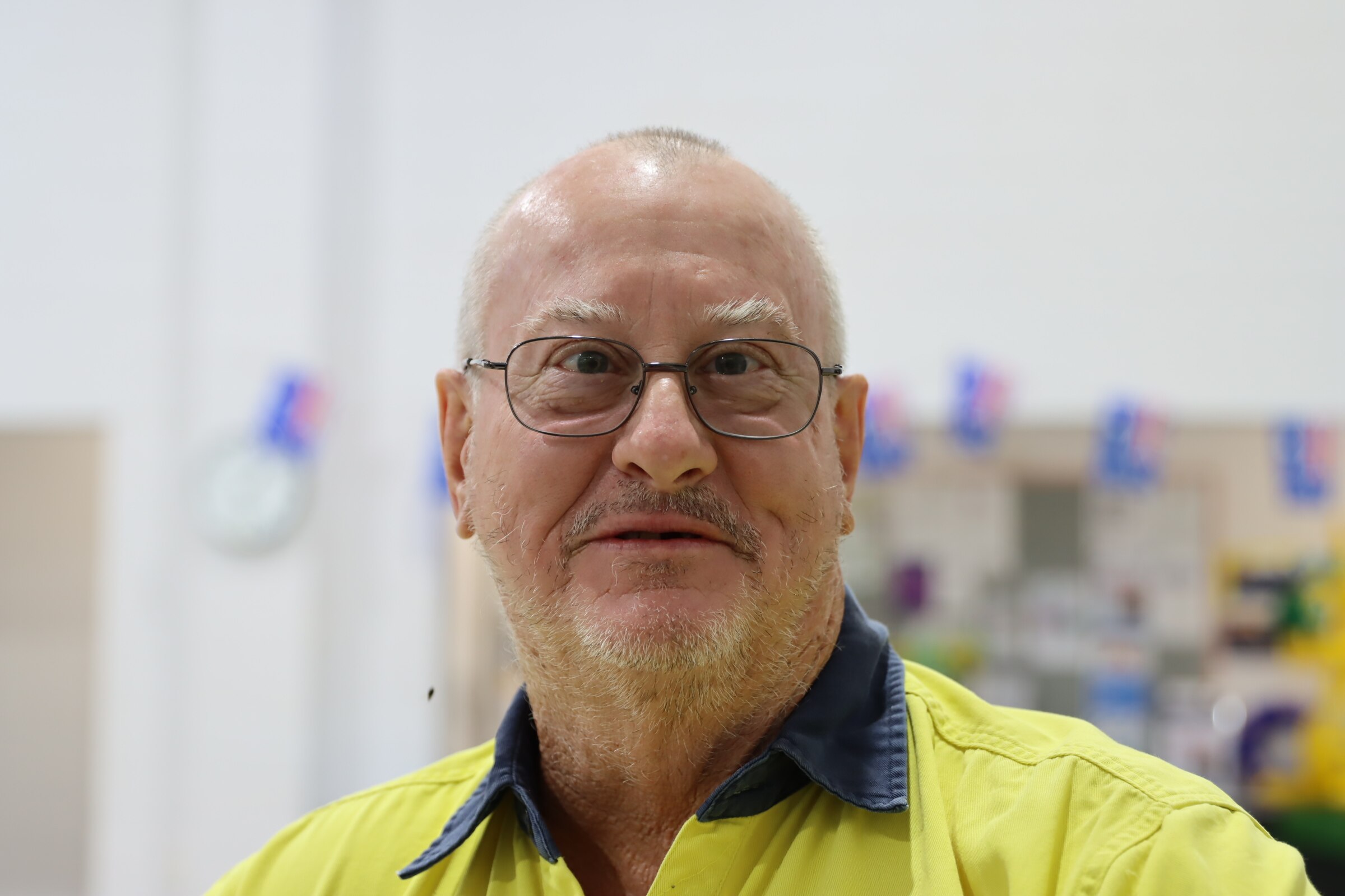 He wears high vis and glasses and looks at the camera