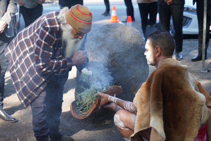 Two people at a smoking ceremony.