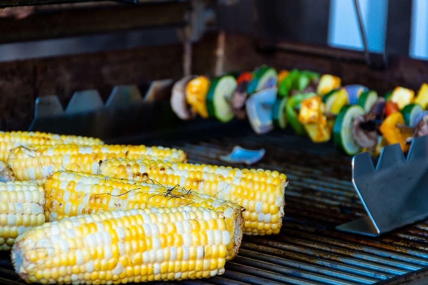 Corn and vegetable kebabs on a BBQ grill.