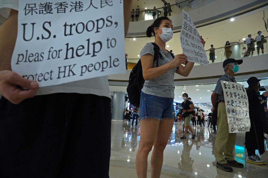 Protesters display placards in a shopping mall during a protest against China's proposed tough national security law.