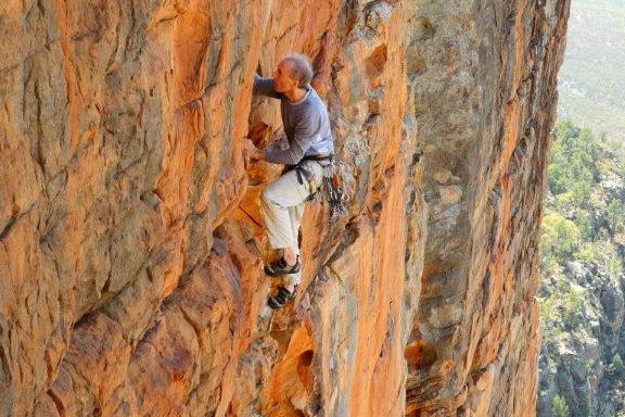 A man climbing a vertical rock wall