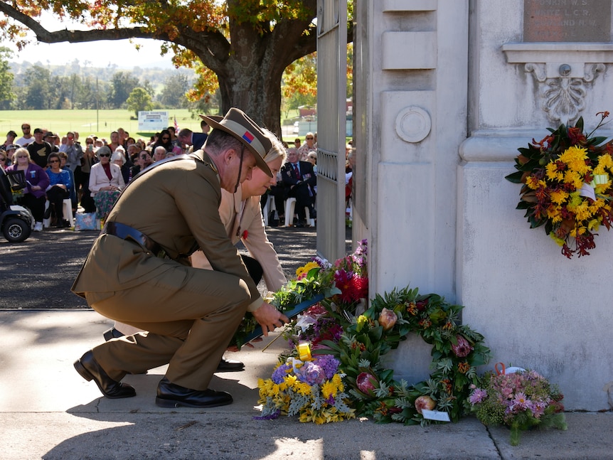 A soldier lays a wreath for anzac day.