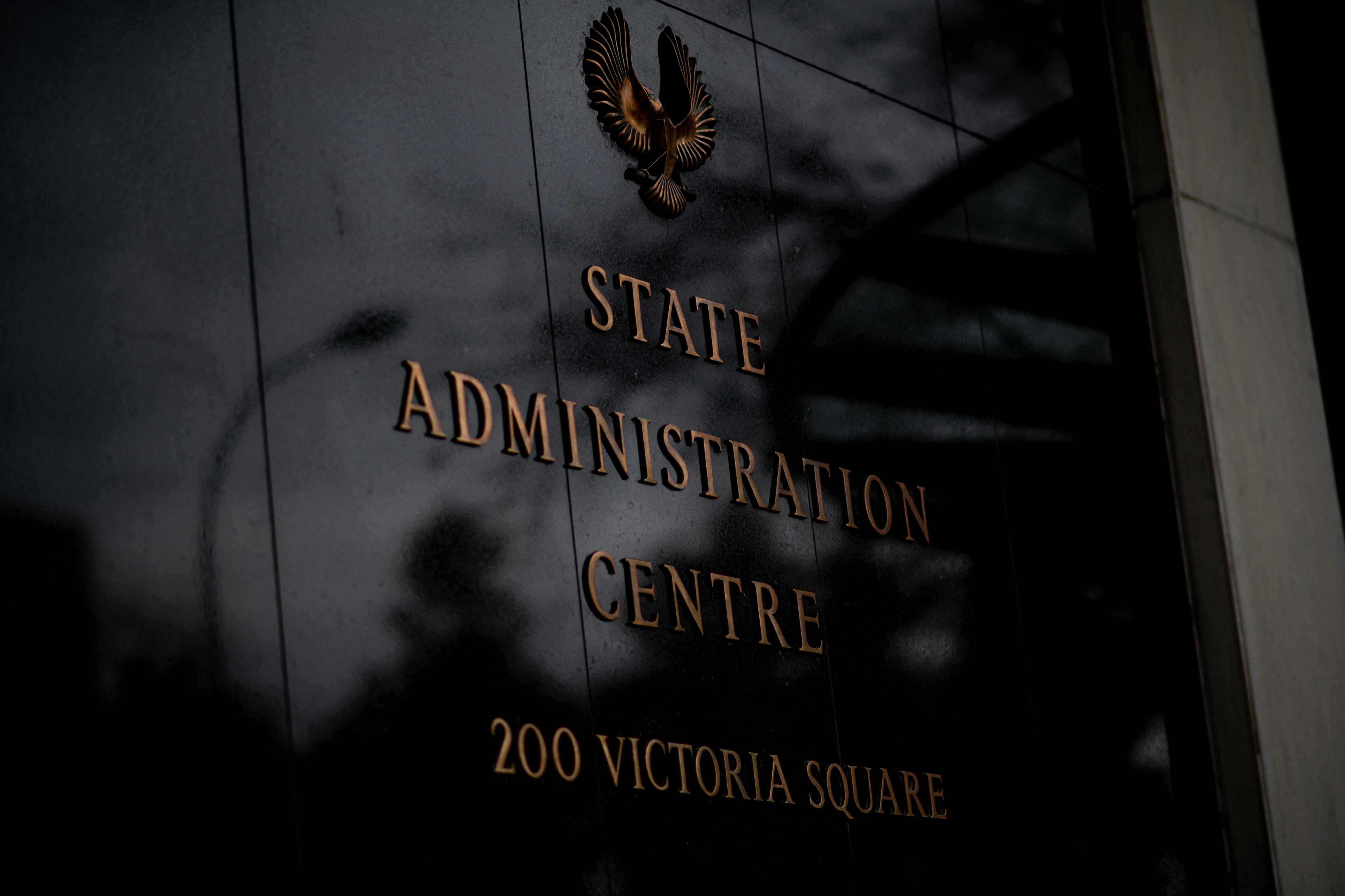 A building name on the wall titled state administration centre with a bird logo