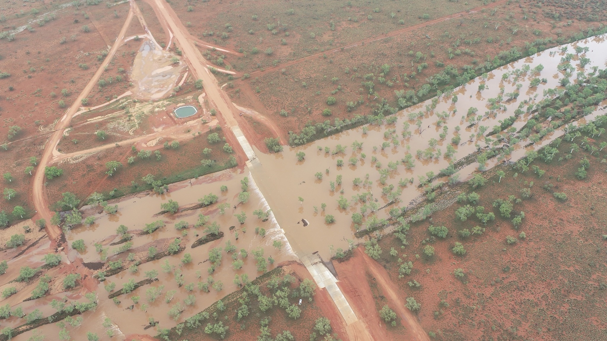 Uma paisagem árida e seca com um enorme rio que a atravessa, cortando uma estrada.