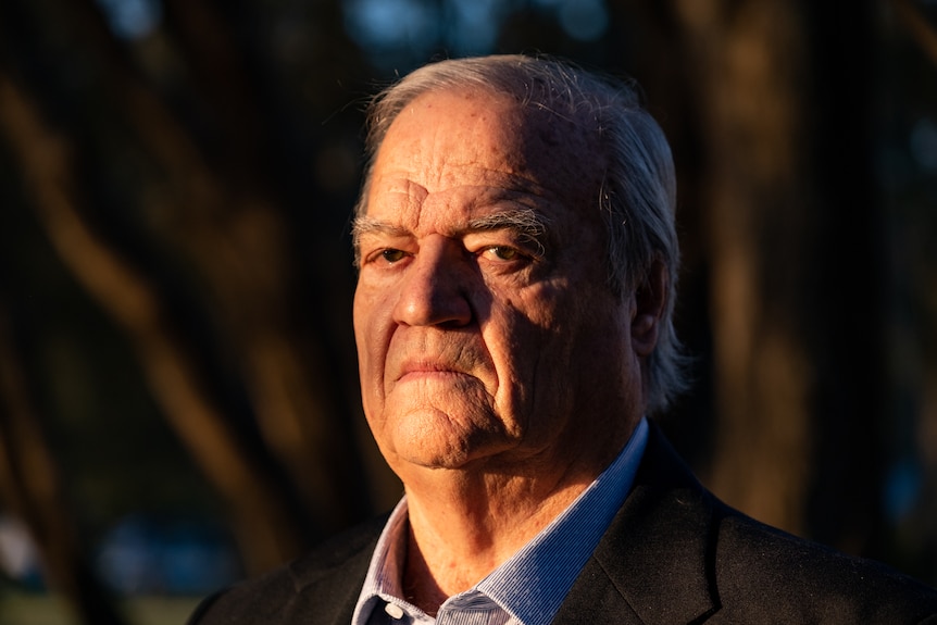 A close portrait of Alan Terrey, who is turning his head to look at the camera, his face is partly in shadow.