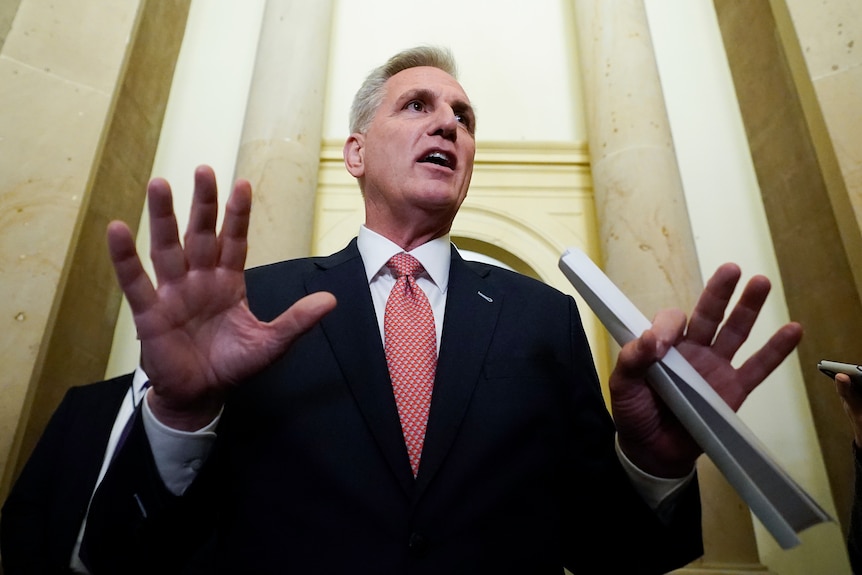 House Speaker Kevin McCarthy holds his hands out as he speaks.