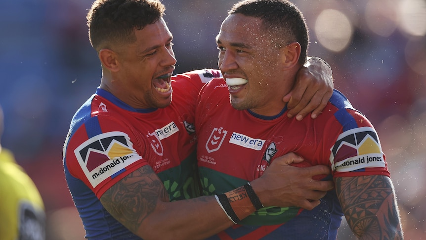 Two men celebrate a try in a rugby league match