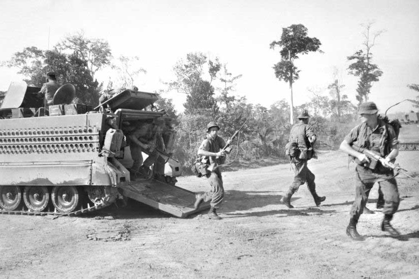 Troops move from an armoured personnel carrier north-east of Saigon in 1965.