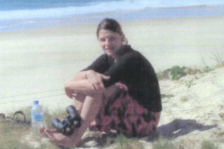 A young woman sitting on the beach.
