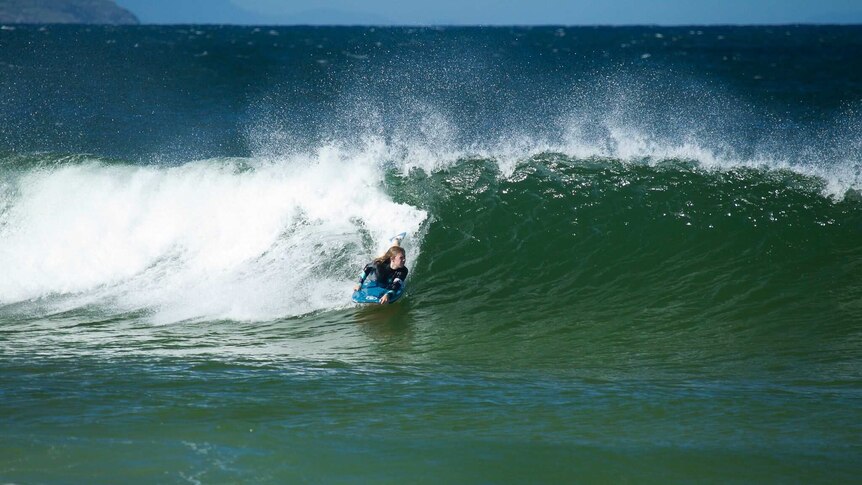 Millie Chalker riding barrel of a wave.