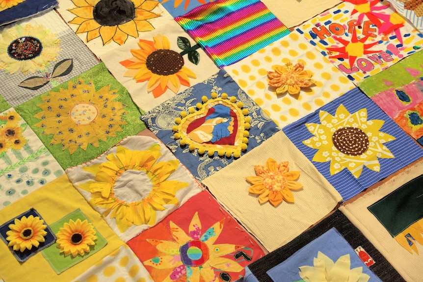 A close up image of a patchwork quilt featuring images of sunflowers