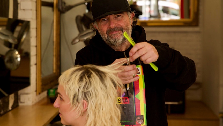 Frank Valvo cutting a woman's hair at his salon
