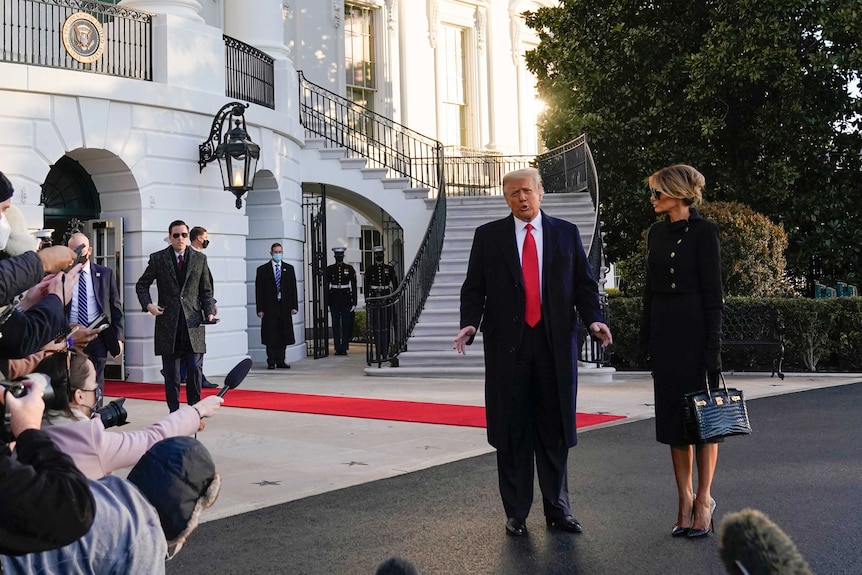 Trumps stand outside White House talking to media