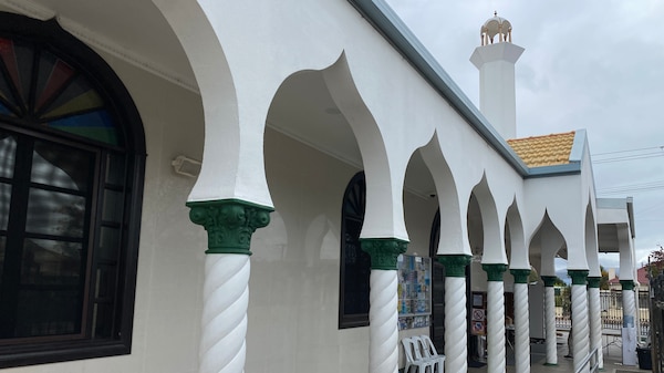 A white building with arches and a minaret