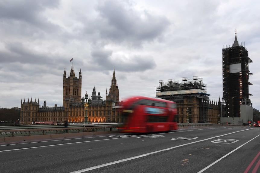 A double decker bus drives along an empty Westminster Bridge.