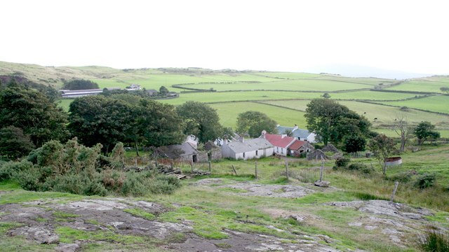 A small group of houses among hills and fields