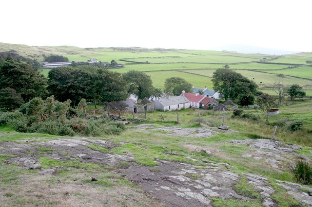 A small group of houses among hills and fields