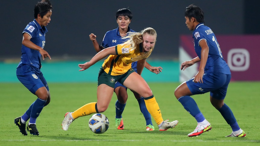 Australia soccer player is surrounded by three defenders at the Asian Cup