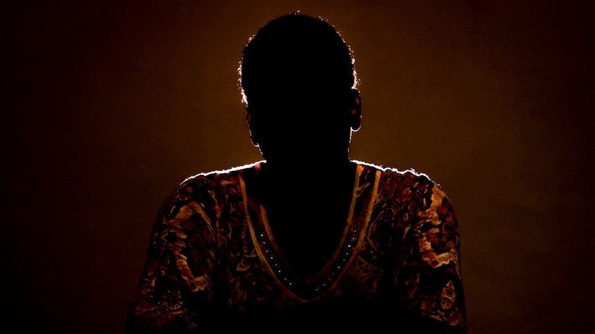 Silhouette of a woman wearing a yellow and red top.