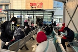 People wait outside a fever clinic at a hospital in Shanghai.