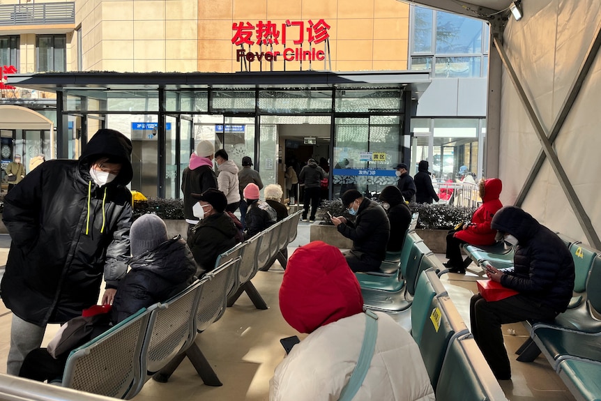 People wait outside a fever clinic at a hospital in Shanghai.