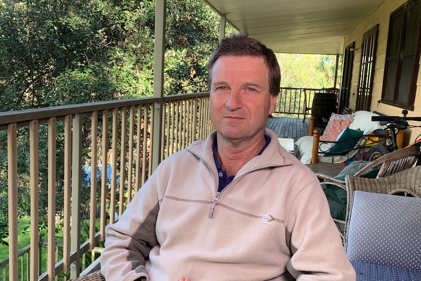 Man wearing jumper sitting on his veranda