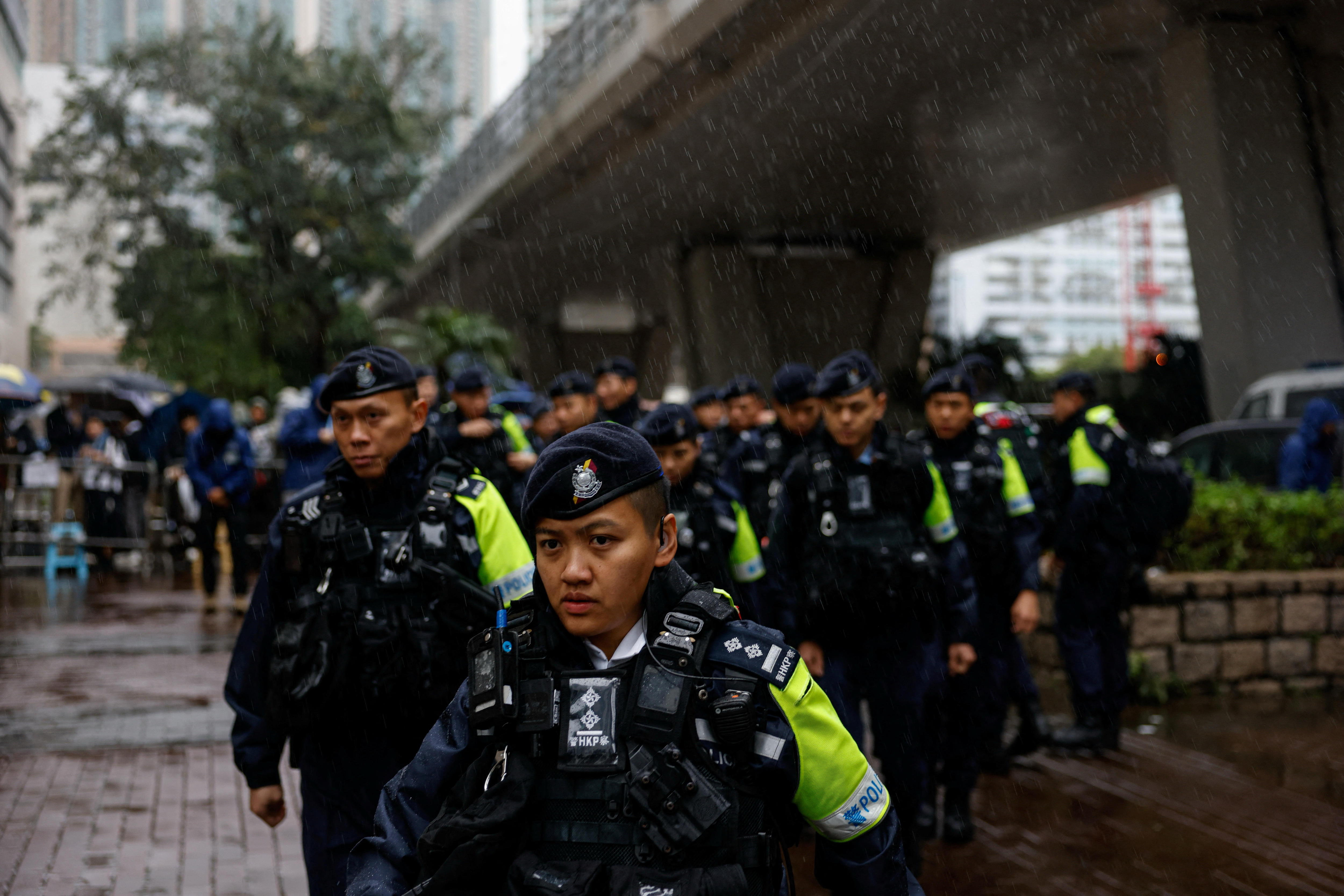 A group of police officers stand in the rain