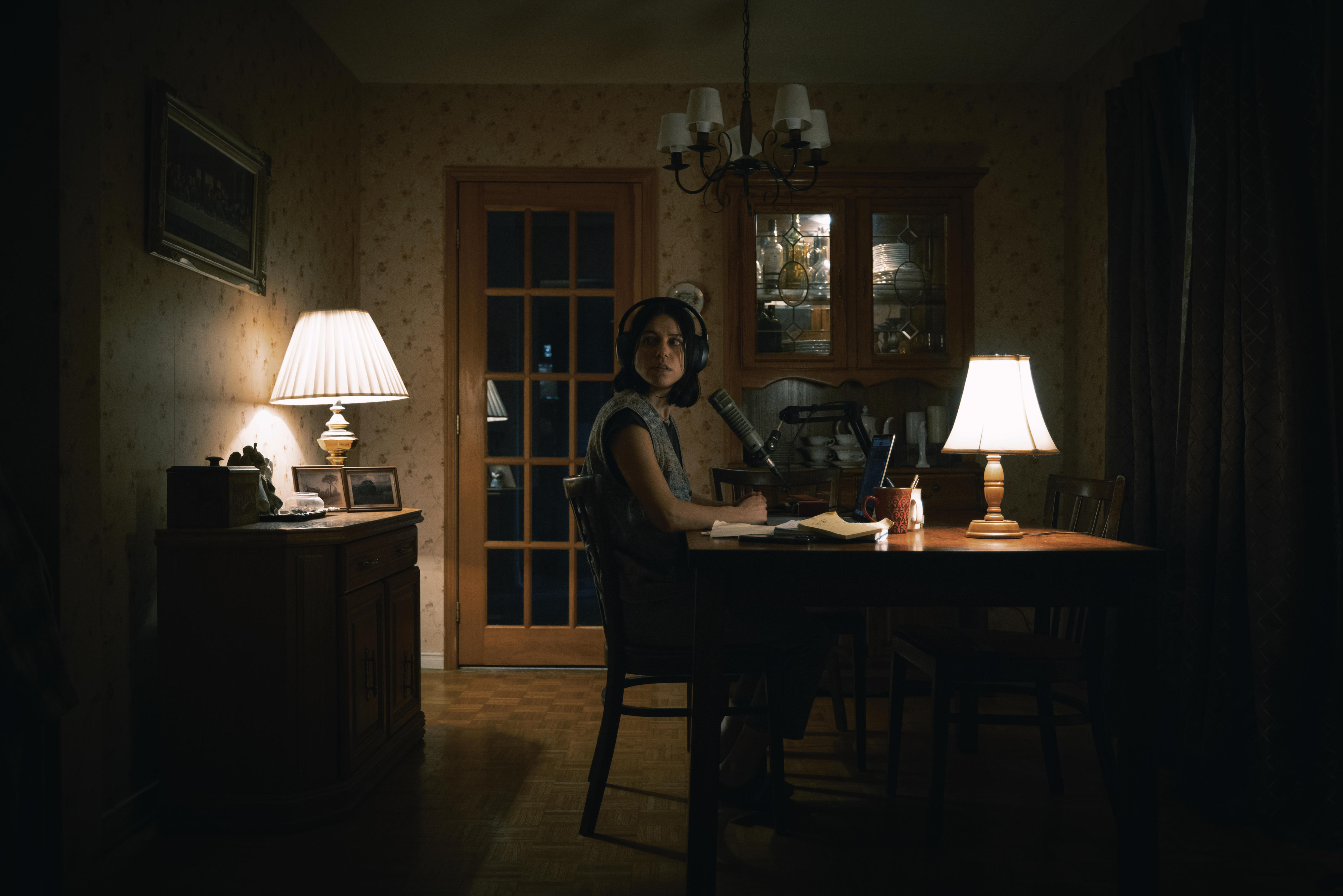 Una mujer sentada en un estudio con dispositivos de grabación.