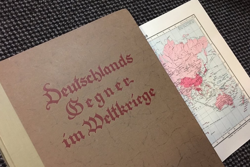 A book in German is pictured, with one page showing of a map of Asia and Australia.
