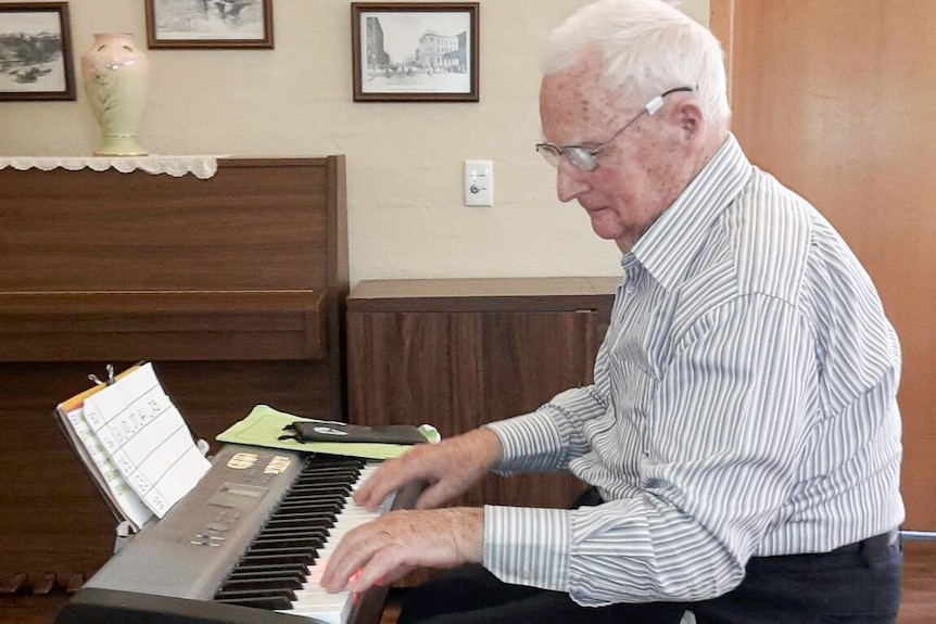 An older man playing a keyboard