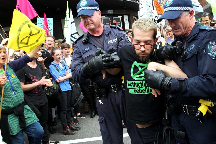A man is arrested by police during an Extinction Rebellion protest