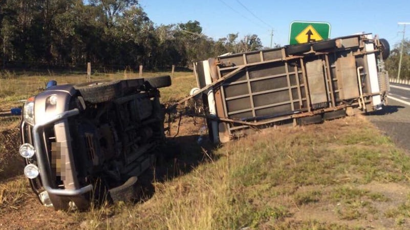 Car towing a caravan is overturned on the side of a highway