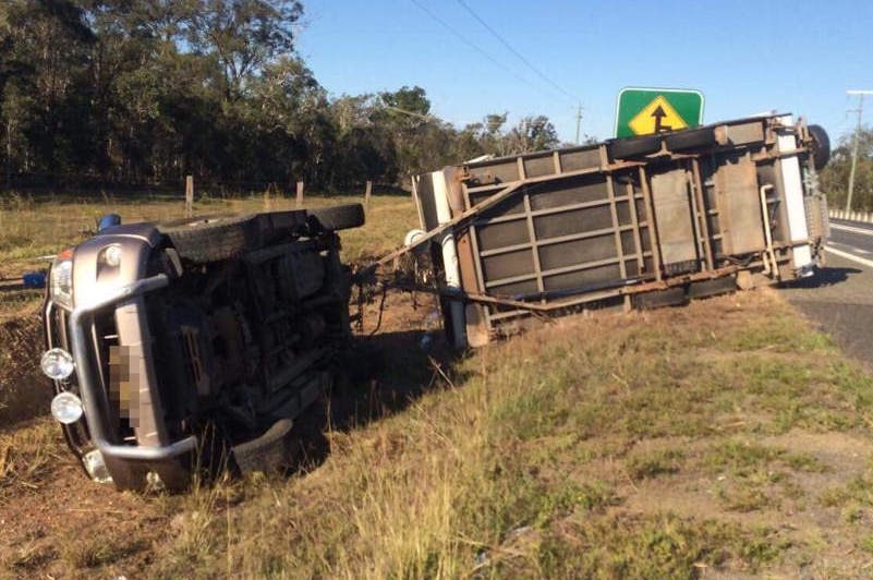 Car towing a caravan is overturned on the side of a highway