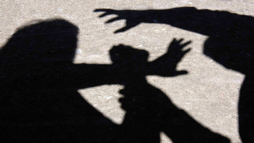 A man grabs a woman's arm through a silhouette on the ground.