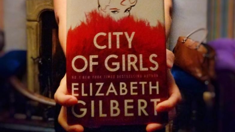 Elizabeth Gilbert holding a copy of her new book, City of Girls.