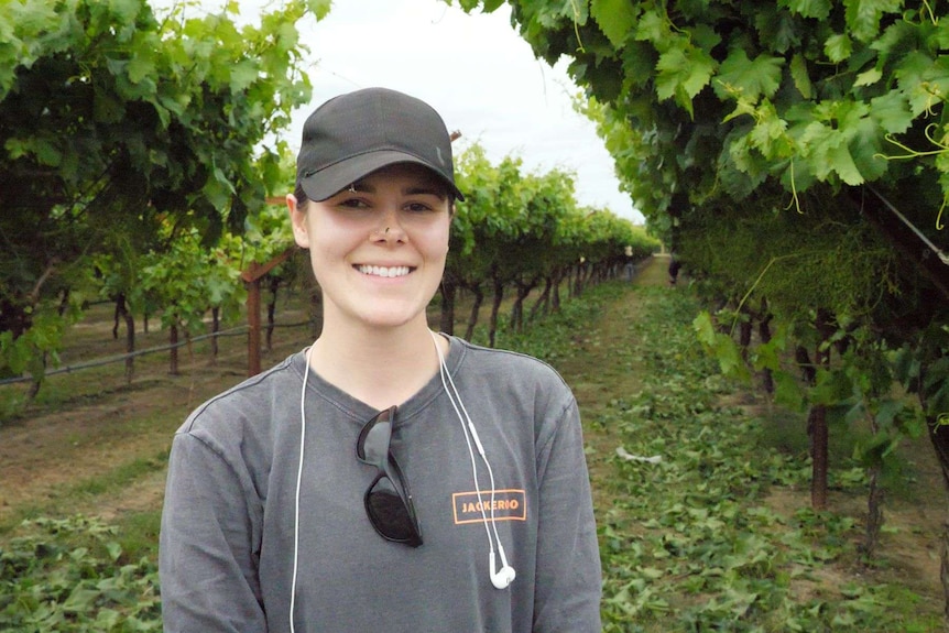 Canadian backpacker Annie Stephenson standing in a vineyard.