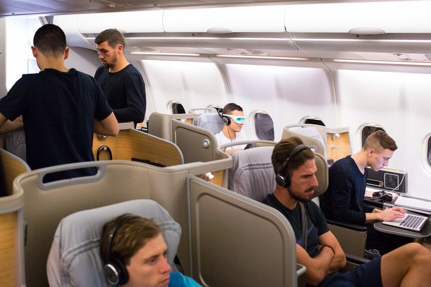 Socceroos players relax during their flight from Honduras to Australia
